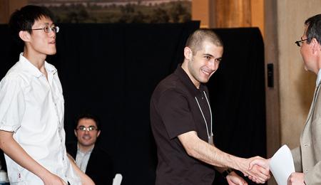 Zehao Hu and Selman Erol accept the Lawrence Robbins Prize from Professor Dirk Krueger.